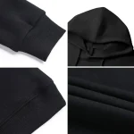 Nahaufnahme von schwarzen Sweatshirt-Ärmeln und Stofftexturen, zeigt die feinen Nähte und die weiche Oberfläche des Materials.