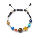 Armband mit Sternen- und Planetenelementen, bunte Perlen und goldene Akzente, ideal für Wissenschafts- und Astronomie-Enthusiasten.