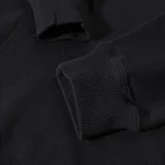 Nahaufnahme eines schwarzen Sweatshirts mit elastischem Bündchen, detailreiche Textur und weiche Stoffqualität sichtbar. Perfekt für lässige Alltagsmode und Komfort.