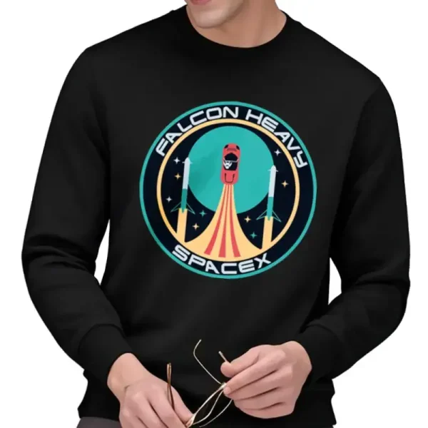 Schwarzes T-Shirt mit Falcon Heavy SpaceX-Logo, das eine startende Rakete vor einem sternenklaren Hintergrund zeigt, ideal für Raumfahrt- und Technologiebegeisterte.
