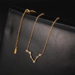 Elegante goldene Halskette mit Sternzeichen-Verschnitt, verziert mit kleinen Diamanten, auf schwarzem Hintergrund. Perfekt für Schmuckliebhaber und Astrologie-Fans.