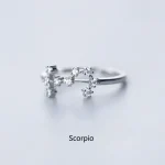 Eleganter Ring in Form des Sternzeichens Skorpion, verziert mit kleinen funkelnden Steinen, auf weißem Hintergrund.