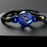 Elegantes Armband mit einem blauen Himmelsglobus-Design, umgeben von schwarzen Schnüren und silbernen Perlen, ideal für Wissenschafts- und Dekorationsliebhaber.