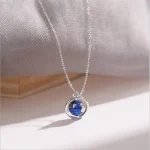 Eleganter Sternenanhänger mit einer kleinen Weltkugel in Blau, der an einer feinen Silberkette hängt. Perfekt für Wissenschafts- und Astronomie-Liebhaber.