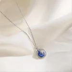 Schlichte Halskette mit einem kleinen, detaillierten Weltkugel-Anhänger in Blau, Silber. Perfekt für Liebhaber von Wissenschaft und globaler Verbundenheit.