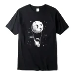 Schwarzes T-Shirt mit weißer Illustration eines Astronauten, der an einer Schnur an einem Mond schwingt, mit dem Wort "Hello" daneben, ideal für Science-Fans.