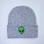 Grauer Beanie mit grüner Alien-Applikation, modisches Accessoire für Science-Fiction-Fans und Trendsetter. Perfekt für kalte Tage und stilvolles Auftreten.