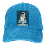 Blaues Cap mit Raumfahrer-Design, das einen Astronauten in Raumanzug zeigt, der zwei Taschen trägt. Perfekt für Science-Fans und Astronomie-Enthusiasten.