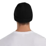 Nahaufnahme einer schwarzen Beanie-Mütze, getragen von einer Person mit heller Haut, Rückenansicht, isoliert auf weißem Hintergrund.