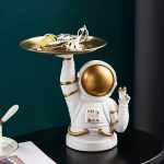 Detaillierte Astronautenfigur mit goldener Raumkapsel, die einen goldenen Teller mit wissenschaftlichen Gegenständen hält, ideal für Dekoration und wissenschaftliche Sammlerstücke.