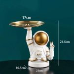 Dekorative Teekanne in Form eines Astronauten mit goldfarbenem Helm und Details.