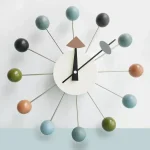 Moderne Wanduhr mit bunten Kugeln und geometrischen Elementen, stilvolles Design für Wissenschafts- und Dekorationsliebhaber.