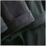 Nahaufnahme eines schwarzen Stoffarmbands mit elastischer Naht, detailreiche Textur, modisches Accessoire.