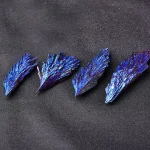 Nahaufnahme von blauen, schimmernden Kristallen auf schwarzem Hintergrund, die wissenschaftliche Mineralien oder Kristalle darstellen.