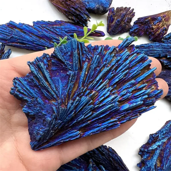 Nahaufnahme von leuchtend blauen Mineralien und Kristallen, die in einer Hand gehalten werden, mit weiteren Kristallen im Hintergrund.
