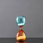 Elegante Glas-Uhr im Sanduhr-Design, die Zeit auf stilvolle Weise misst, ideal für wissenschaftliche Dekorationen und moderne Inneneinrichtung.