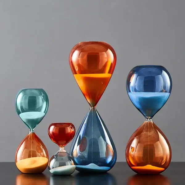 Bunte Sanduhren in verschiedenen Größen und Farben, die auf einem schwarzen Tisch stehen, symbolisieren Zeit und Wissenschaft in moderner Dekoration.