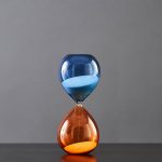 Sanduhr mit blauer und orangefarbener Flüssigkeit, wissenschaftliches Dekor.