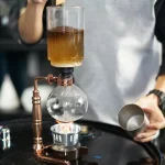 Wissenschaftliches Experiment mit chemischer Reaktion, Glasgefäßen und Reagenzglas, ideal für Bildung und Dekoration.