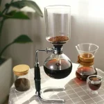 Wissenschaftliches Kaffee-Extraktionssetup mit Glasapparat und Zubehör, ideal für Bildungszwecke und Dekoration.