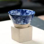 Elegante blaue wissenschaftliche Schale aus Keramik auf einem weißen Sockel, ideal für Dekorationen oder wissenschaftliche Präsentationen.