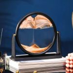 Wissenschaftliches Dekorationsobjekt mit einem kreisförmigen, künstlerischen Sandpendel, das auf einem Stapel Bücher steht, ideal für wissenschaftliche oder moderne Raumgestaltung.