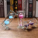 Sanduhr-Set aus Glas mit pink, blau und lila Sand, perfekt für wissenschaftliche Dekorationen und als Lernhilfe.