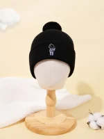 Schwarze Mütze mit Wissenschafts-Logo und Bommel, ideal für kalte Tage, auf einem Holzständer präsentiert. Perfekt für Wissenschafts- und Technikliebhaber, stilvoll und funktional.