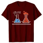 Lustiges T-Shirt mit zwei Reagenzgläsern, eines mit blauer Flüssigkeit und das andere mit roter, das sprudelt, mit humorvollem Text "I think you're overreacting".