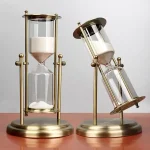 Dekorativer Sanduhr-Timer mit goldfarbenem Rahmen und Glasbehältern.