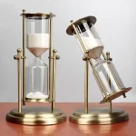 Sanduhr mit goldfarbenem Rahmen und zwei Glasbehältern, die mit Sand gefüllt sind, ideal für wissenschaftliche Dekorationen oder als stilvolles Accessoire.