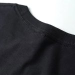Nahaufnahme eines schwarzen T-Shirts mit Rundhalsausschnitt, Stoffdetails sichtbar, modisches Basic für Alltag und Freizeit.