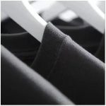 Schwarzes Hemd auf einem weißen Kleiderbügel, Nahaufnahme, modisches und elegantes Design, ideal für formelle Anlässe.