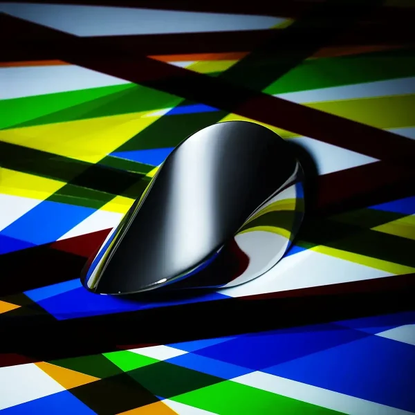 Hochwertige, moderne Computermaus mit reflektierender Oberfläche auf einem farbenfrohen, geometrischen Hintergrund. Perfekt für Technik- und Wissenschaftsdekorationen.