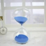 Elegante Sanduhr mit blauer Sandfüllung, ideal für wissenschaftliche Dekorationen und moderne Inneneinrichtung.