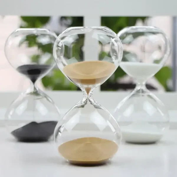 Eleganter Sanduhr-Timer aus transparentem Glas mit beigefarbenem Sand, ideal für wissenschaftliche Dekorationen und Lernzwecke.