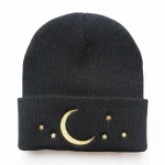 Schwarze Strickmütze mit goldener Mond- und Sternstickerei, ideal für kalte Tage, kombiniert wissenschaftliches Design mit modischem Stil.