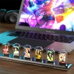 Detaillierte Modelle von Fußballspielerinnen in transparenten Glasvitrinen, präsentiert auf einem schwarzen Sockel, vor einem Laptop mit buntem, futuristischem Hintergrund.