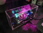 Elektronischer Schaltkreis in transparentem Gehäuse mit LED-Anzeige und Komponenten, ideal für Wissenschafts- und Technik-Dekorationen.