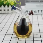 Glasflasche mit dunkler Flüssigkeit und zwei Röhren, ideal für wissenschaftliche Experimente und Dekoration.