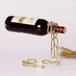 Dekorative Flasche, die an eine Bombe erinnert, mit goldener Kette um den Hals, auf weißem Hintergrund.