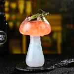 Kreativer Cocktail in einem wissenschaftlichen Glas mit Eis, Minze und Kirsche, perfekt für Sommerpartys und Getränkepräsentationen.