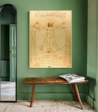 Illustration des Vitruvianischen Menschen von Leonardo da Vinci, ausgestellt in einem grünen Raum mit Spiegel und Holztisch, erinnert an die Kunst und Wissenschaft der Renaissance.
