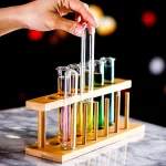 Wissenschaftliches Reagenzglas-Set mit bunten Flüssigkeiten auf Holzständer, ideal für Dekoration und wissenschaftliche Experimente.