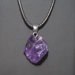 Anhänger mit rohem Amethyst-Kristall an silberner Kette, naturbelassenes Edelstein-Design, ideal für Schmuckliebhaber und Kristall-Sammler.