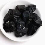 Natürliche schwarze Turmaline in einer weißen Schale, ideal für wissenschaftliche Dekorationen und Mineralien-Sammlungen.