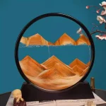 Detailliertes Bild einer dekorativen Berglandschaft im Glas, mit orangefarbenen Bergen und blauer Hintergrund, ergänzt durch eine kleine Figur und Blütenzweig.