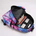 Rucksack mit Weltraum-Galaxie-Motiv, geöffnet, zeigt Bücher, Stifte und elektronische Geräte, ideal für Schüler und Wissenschaftsbegeisterte.