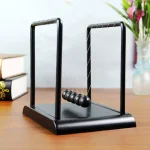 Klassische Newton-Wiege mit fünf schwarzen Kugeln, ideal für Physik- und Wissenschaftsdekorationen.