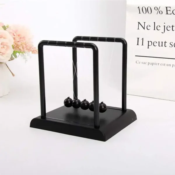 Moderne magnetische Newton-Wiege mit schwarzen Kugeln auf schwarzem Sockel, ideal für wissenschaftliche Dekorationen und Bildungszwecke.